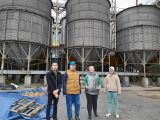 Czworo uczniów stoi przy silosach zbożowych