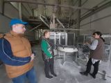Dwoje uczniów w wysokim pomieszczeniu. Za nimi taśmociąg