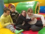 Dwóch chłopców i dwie uśmiechnięte dziewczynki w gumowym kolorowym basenie przytulają sie do siebie