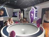 Czworo uczniów pochylonych nad biało fioletowym urządzeniem - lejem