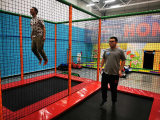 Dwóch chłopców skacze na trampolinie.