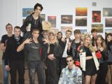Na korytarzu szkolnym stoi duża grupa uczniów liceum. Wszyscy ubrani są na czarno. Wśród uczniów jeden chłopak siedzi...