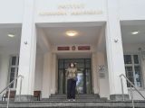 Nastolatka przed wejściem do budynku Instytutu Aleksandra Jabłońskiego.
