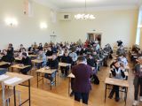 Grupa kilkudziesięciu nastolatków w sali konkursowej.