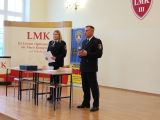 Dwoje mundurowych, przemawia do młodzieży. w tle napis  LMK III Liceum Ogólnokształcące im. Marii Konopnickiej we Włocławku