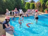 Uczniowie w strojach plażowych w basenie zewnętrznym