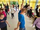 Uczniowie w strojach sportowych ćwiczą ustawieni w kręgu
