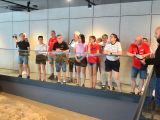 W sali muzealnej przy balustradzie stoi kilkanaście osób w róznym wieku. Każdy patrzy przed siebie.