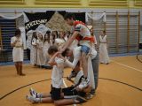 Nastolatkowie wykonujący figurę akrobatyczną w tle sala gimanstyczna